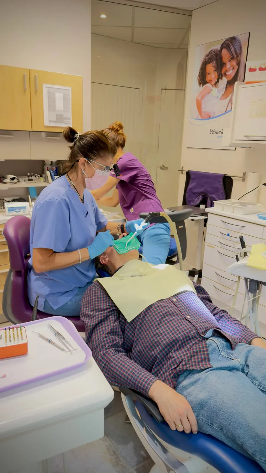 Dr. Flavia providing dental care while a team member assists